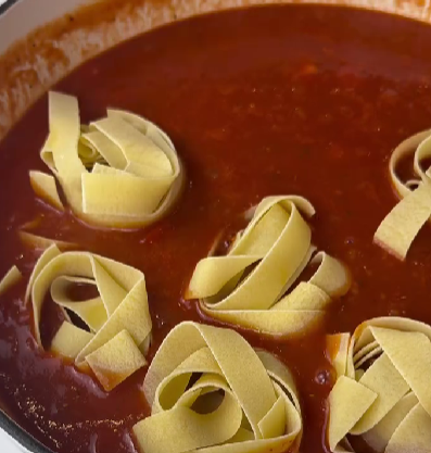 Step 5.2: Pour in the tomato purée and broth