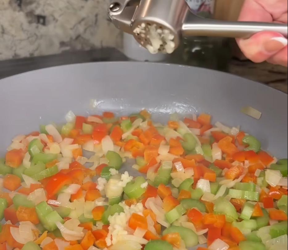 Step 2.1: Add diced yellow onion, celery, and red bell pepper to the skillet