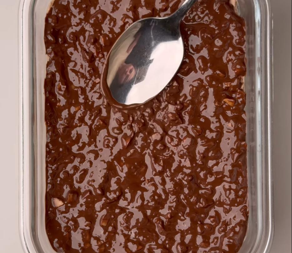 Step 1.1: Melt the chocolate with the coconut oil, pour it over the mixture, and sprinkle with chopped roasted peanuts