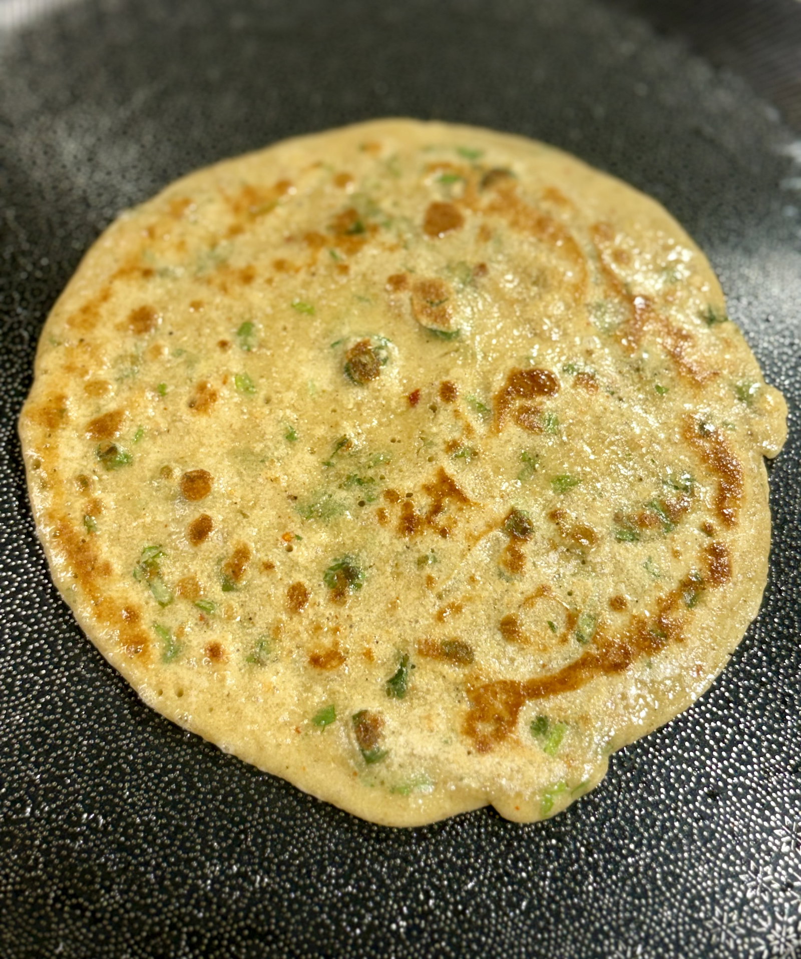 Step 1.1: **Flip and Crisp: **Carefully flip the paratha, press down gently with a spatula, and cook for 1–2 minutes until golden-brown spots appear on both sides