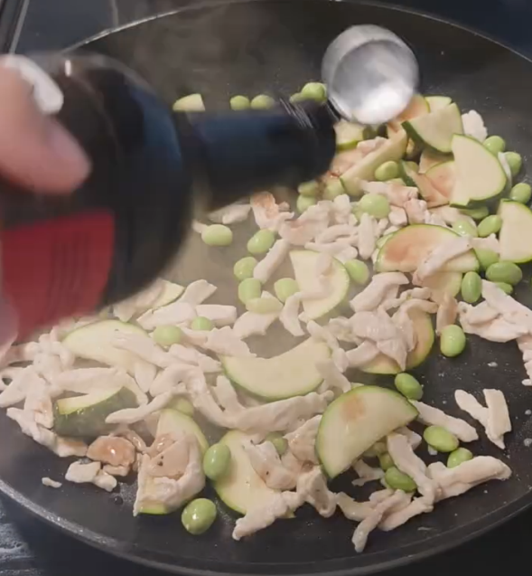 Step 3.1: Add in the zucchini and edamame with a splash of extra soy sauce to season