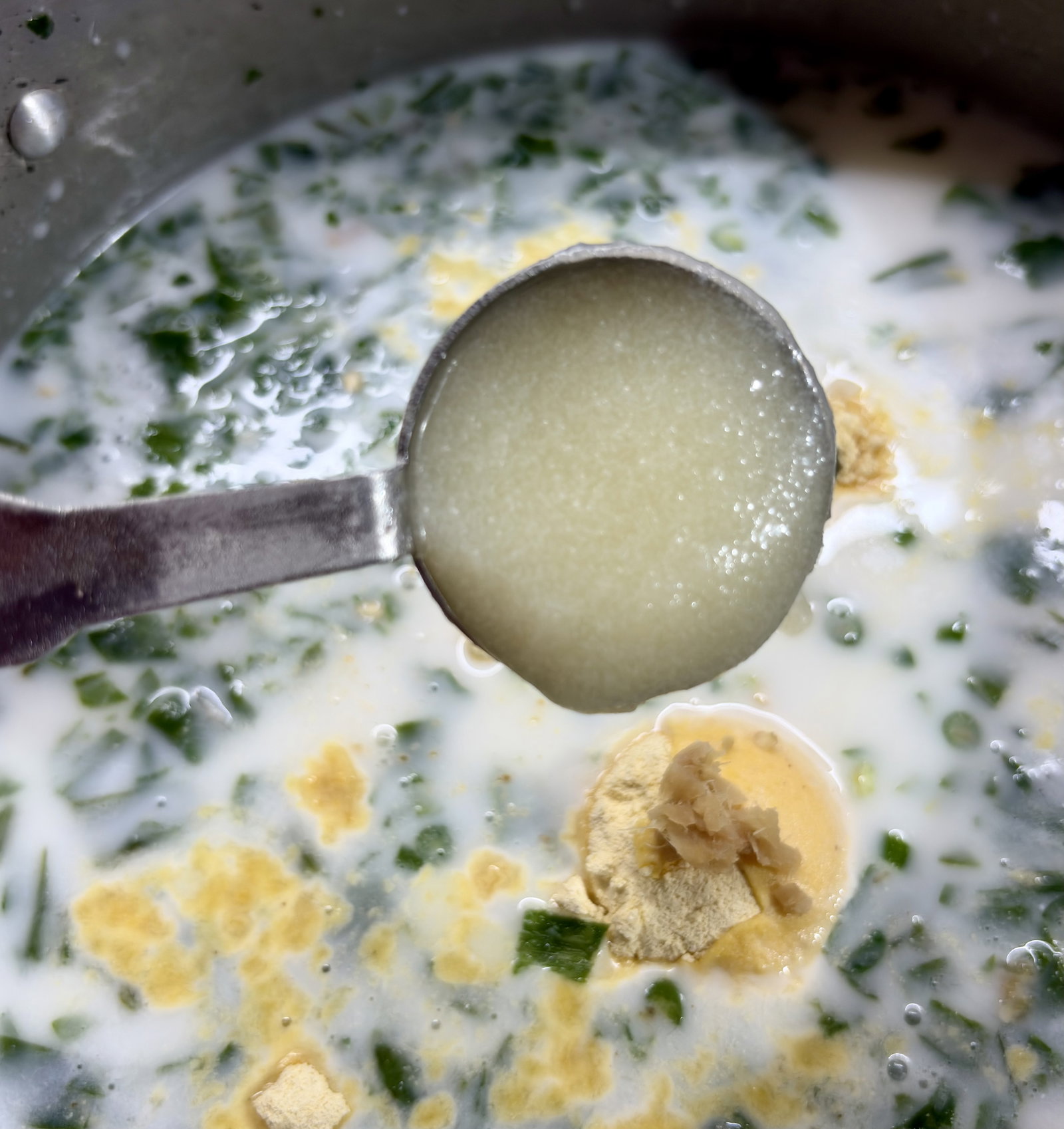 Step 2.1: In a deep, heavy-bottomed pot, mix sour buttermilk, spinach, soaked rice, gram flour, green chillies, ginger, asafoetida, salt, and ghee