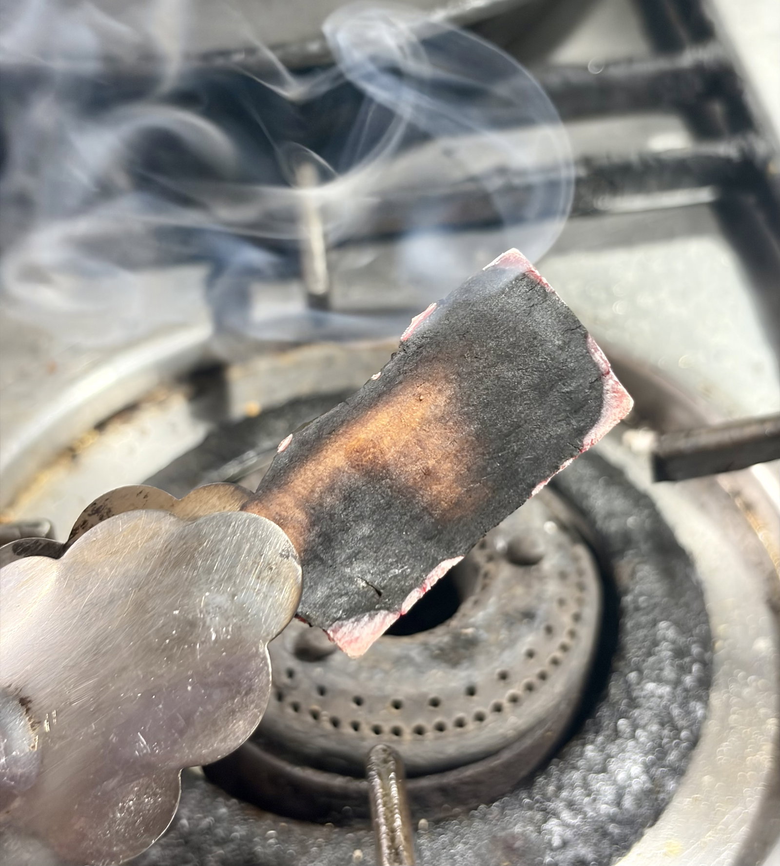 Step 1.2: Hold the cinnamon stick over a low flame using tongs for a few seconds until it gets lightly charred and smells fragrant