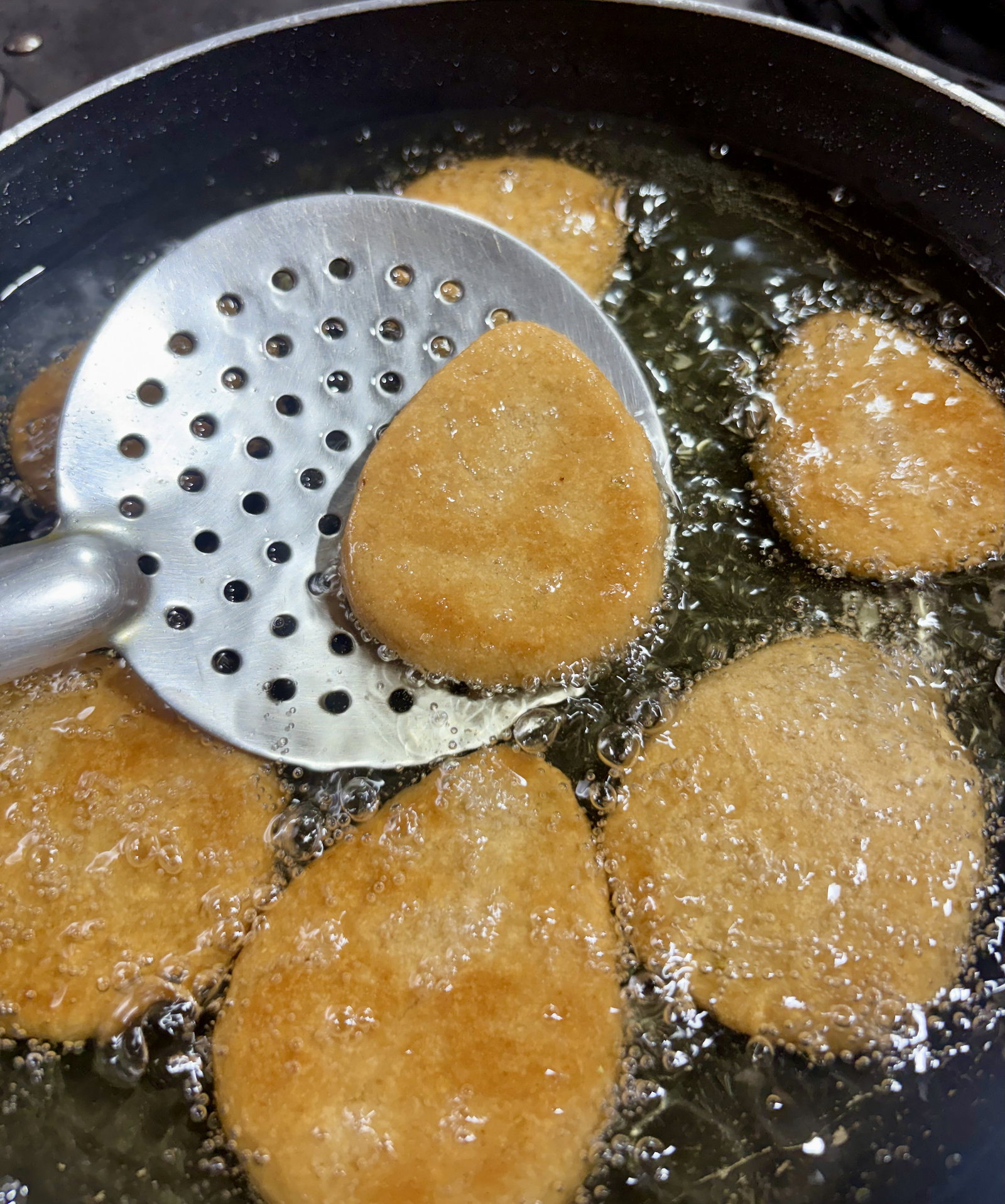 Step 5.2: Gently drop the shaped discs into the hot oil in batches