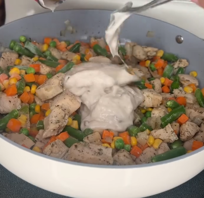 Step 1.1: Stir in frozen mixed vegetables, cream of mushroom soup, cream of chicken soup, and cooked rotini pasta until well combined