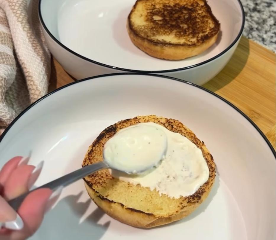 Step 5.1: Spread garlic aioli onto the bottom bun