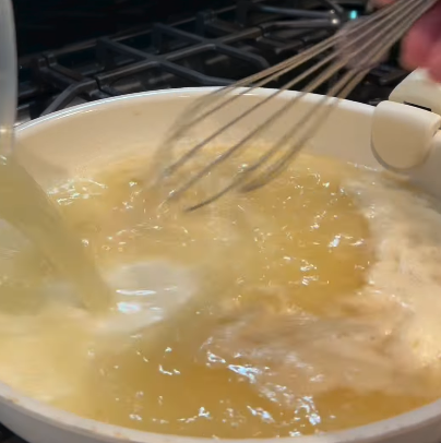Step 3.1: Slowly pour in 2 cups of chicken broth while stirring continuously