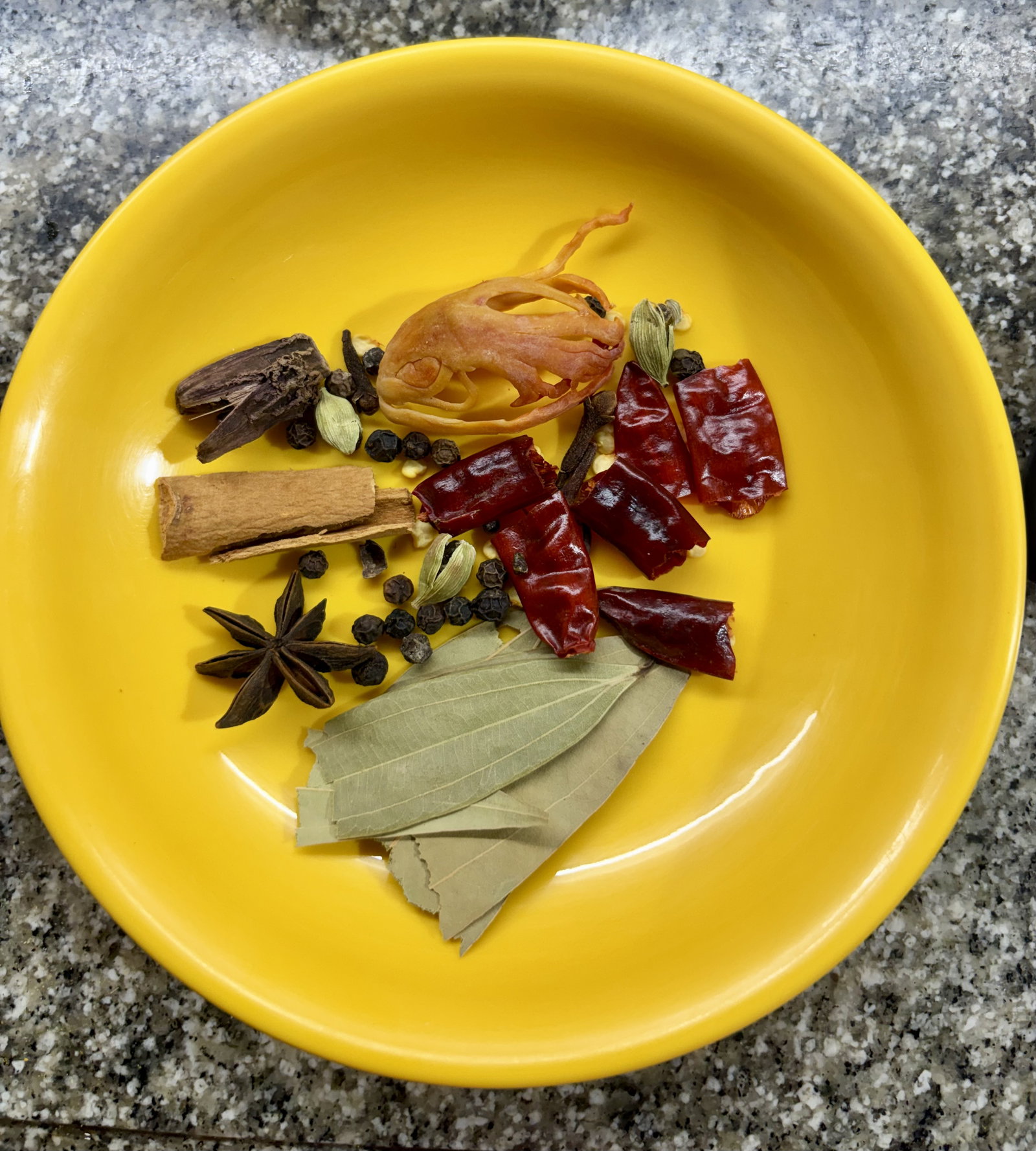 Step 2.1: Reduce the heat and add the cinnamon, cloves, black cardamom, green cardamom, mace, star anise, black peppercorns, dried red chillies, and bay leaf