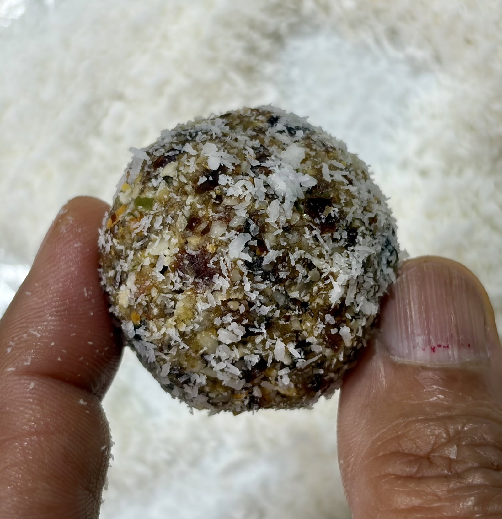 Step 4.1: Roll each ball generously in desiccated coconut to form a light outer layer, then set aside on a plate or tray