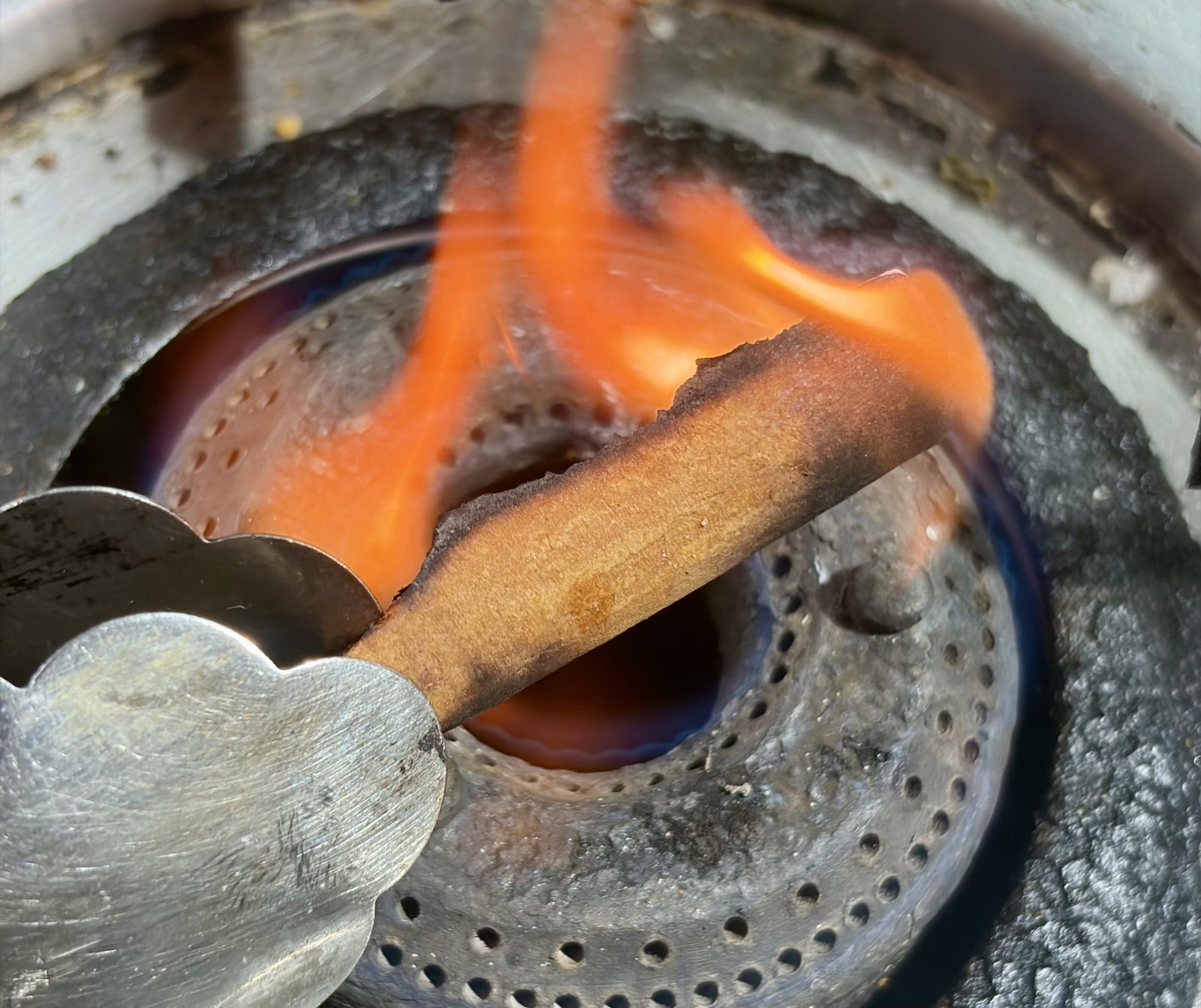 Step 1.1: Hold the cinnamon stick over a low flame using tongs for a few seconds until it gets lightly charred and smells fragrant