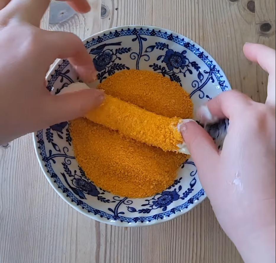 Step 1.1: Dip mozzarella sticks in mayonnaise, then coat evenly with breadcrumbs