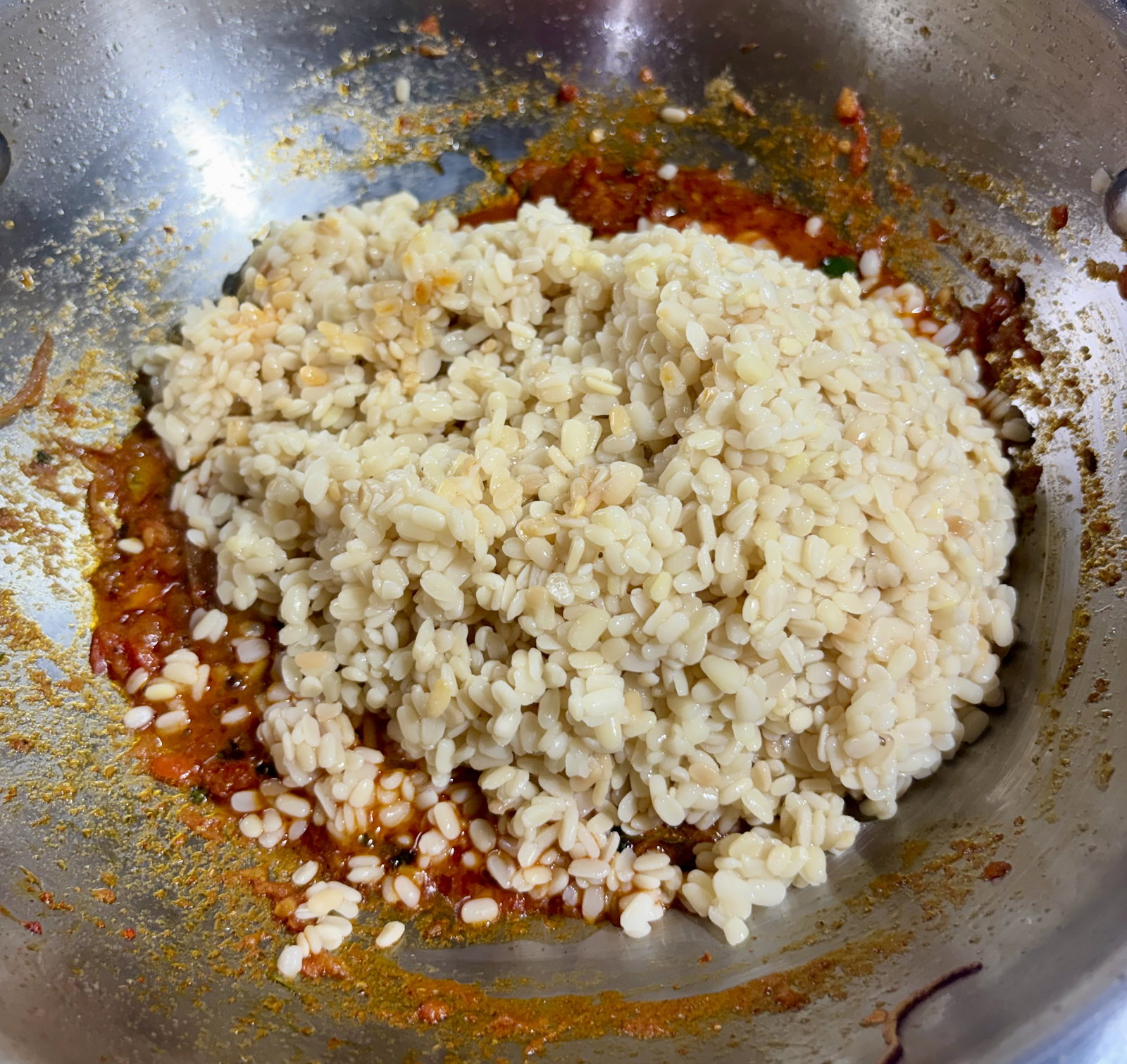 Step 3.1: Add the cooked dal into the masala pan, mixing carefully to combine without mashing the lentils