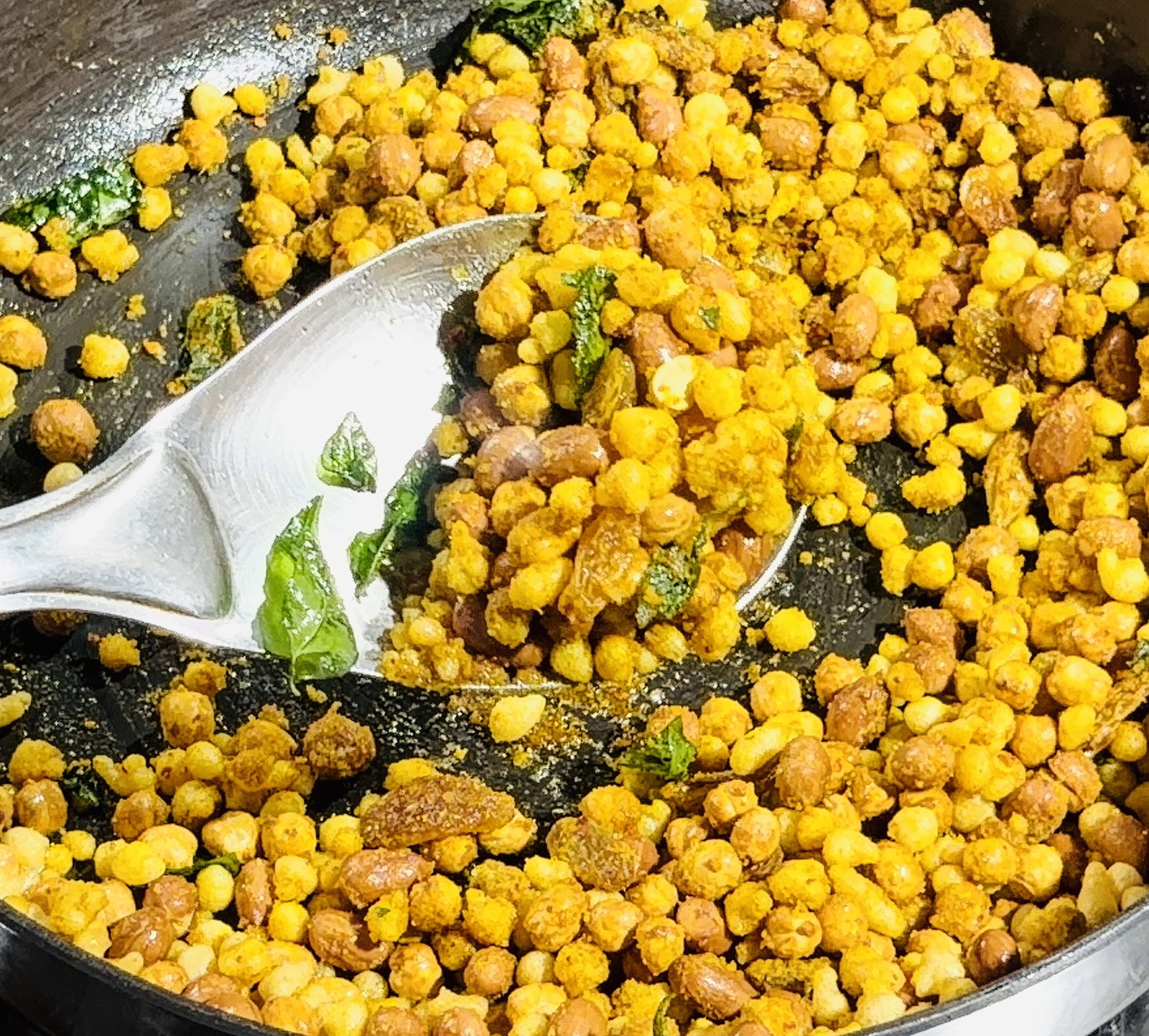 Step 3.2: Sprinkle the prepared spice mix over the mixture and stir quickly to coat the fried nuts, raisins, and boondi evenly