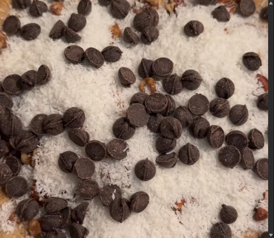 Step 3.1: Sprinkle chopped pecans, walnuts, GF/DF chocolate chips, and shredded coconut evenly over the cooled crust