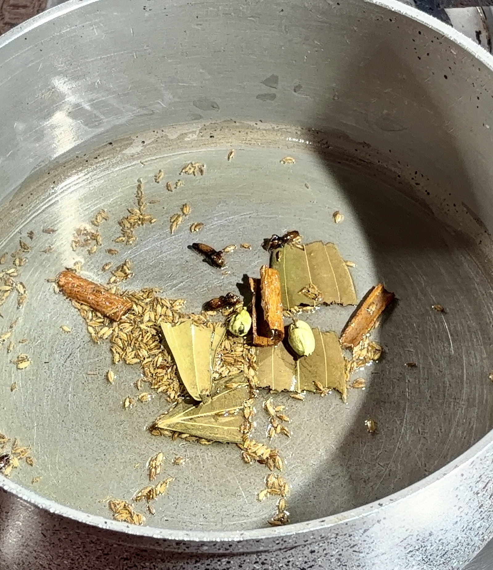 Step 2.1: Add the cumin seeds, bay leaf, cloves, cinnamon, and green cardamom