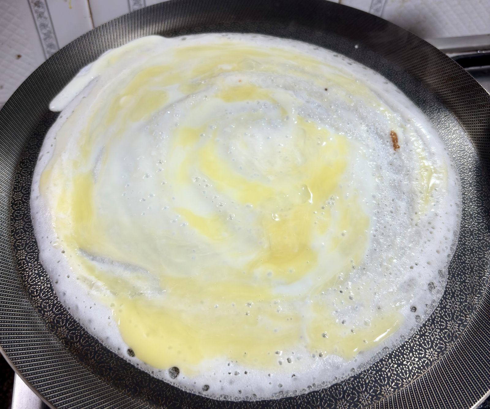 Step 4.1: Use a spatula or the back of a spoon to gently break the yolk and spread the egg evenly across the batter's surface