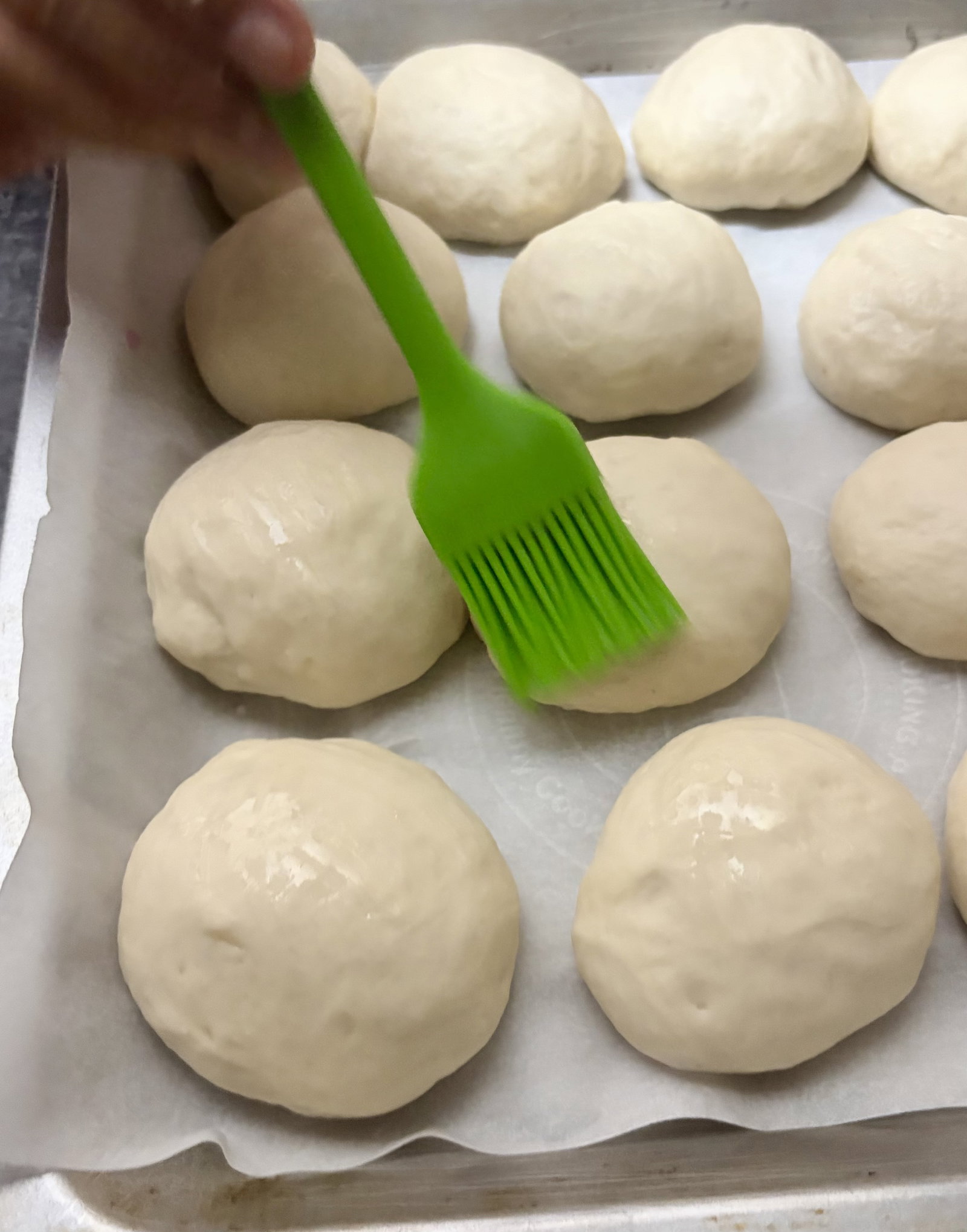 Step 5.1: Gently brush the tops of the dough balls with milk