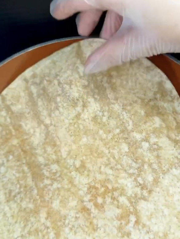 Step 1.1: Place flour tortilla directly on top of the eggs and gently press it down