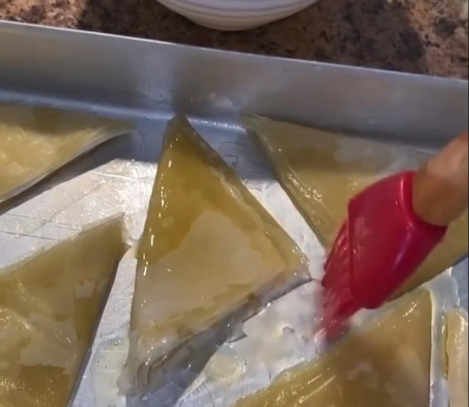 Step 1.1: Brush the filo pastry with ghee and sunflower oil and fold into triangles