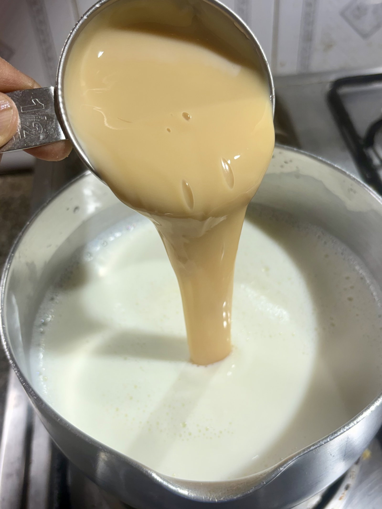 Step 1.1: Stir in the condensed milk and cardamom powder