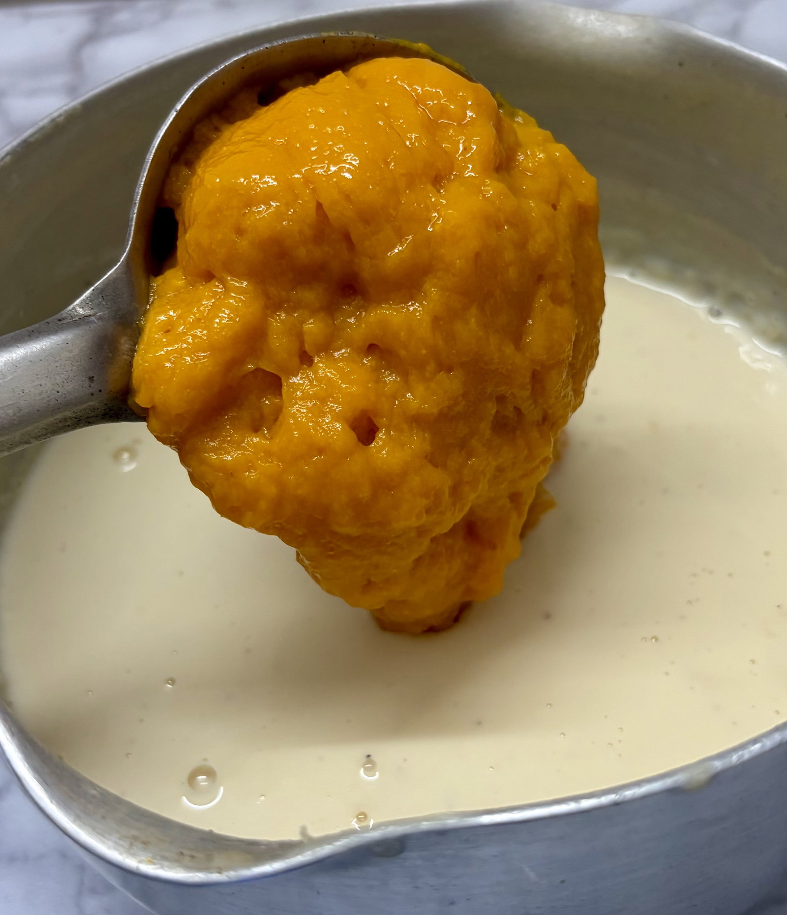 Step 2.1: Gently fold in the thick mango pulp and fresh cream (if using)