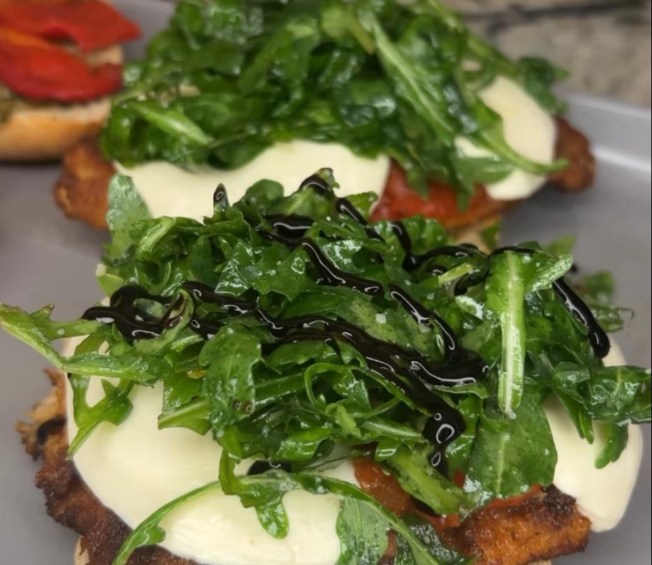 Step 2.1: Finish assembling the sandwich by adding pesto, roasted red peppers, arugula, and a drizzle of balsamic glaze
