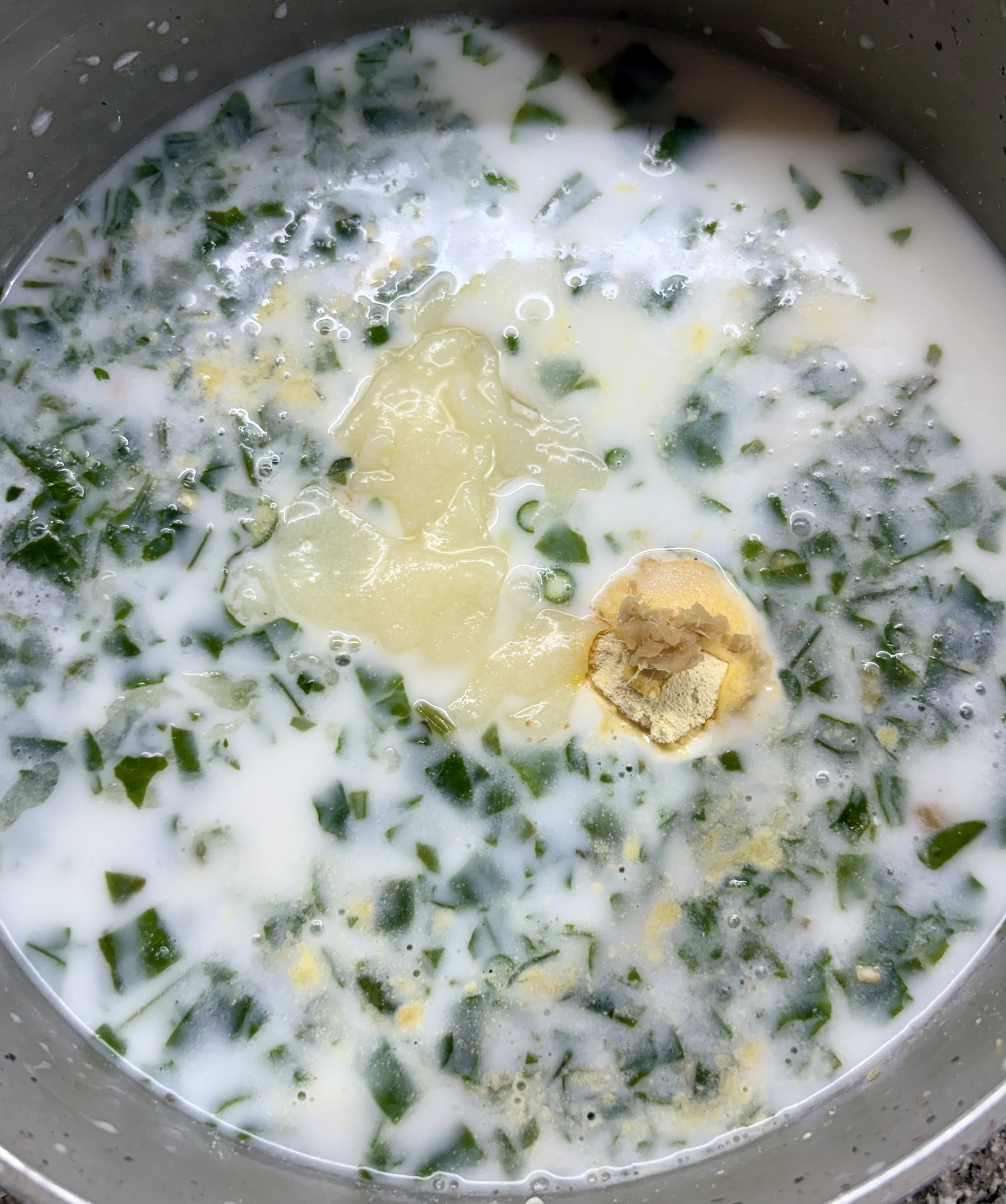 Step 2.2: In a deep, heavy-bottomed pot, mix sour buttermilk, spinach, soaked rice, gram flour, green chillies, ginger, asafoetida, salt, and ghee