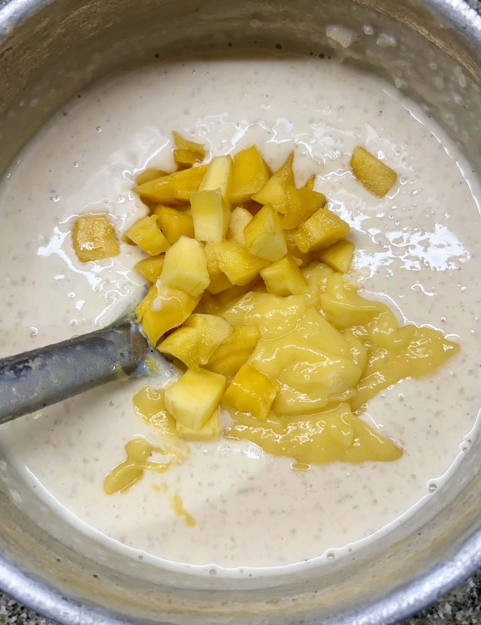 Step 4.1: Gently stir in the mango pulp and chopped mango chunks until well combined