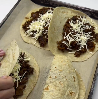 Step 1.1: Spoon the chicken onto each tortilla, top with a generous handful of cotija cheese, and fold into a half-moon shape