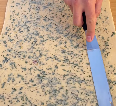 Step 1.1: Spread the garlic herb filling evenly over the dough