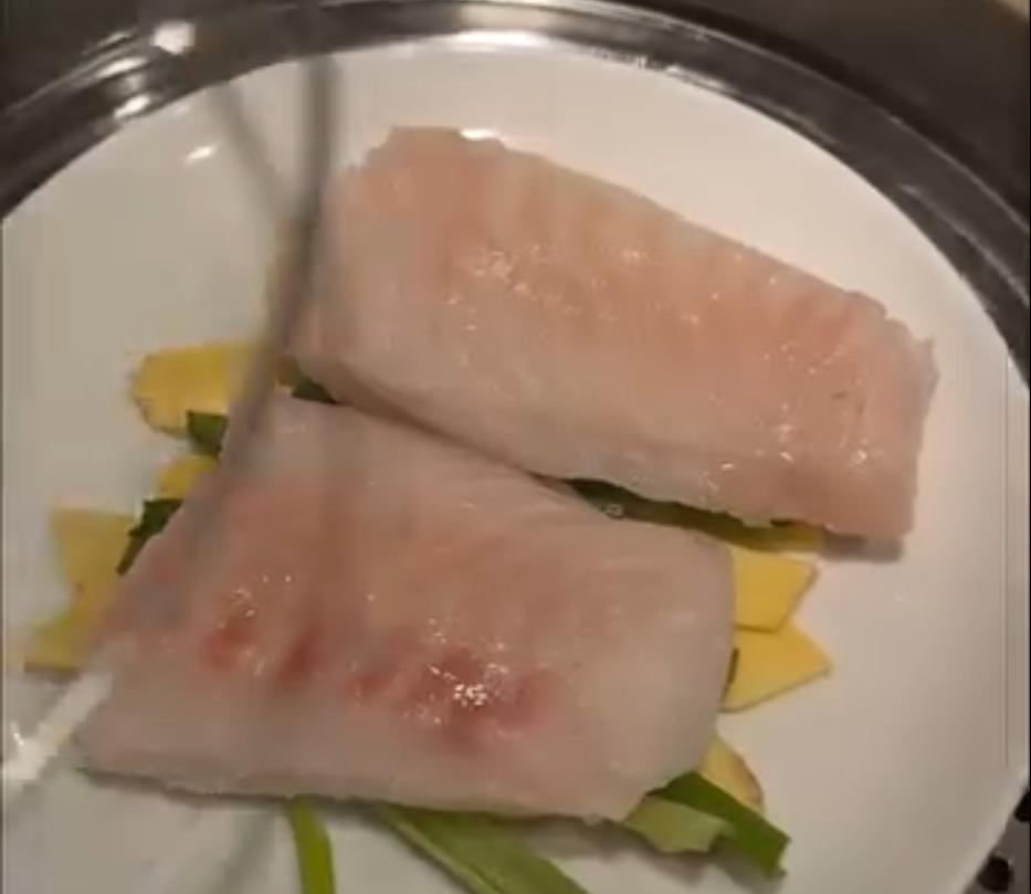 Step 1.1: Lay ginger slices and a few pieces of scallion on a plate, then place the cod fillets on top