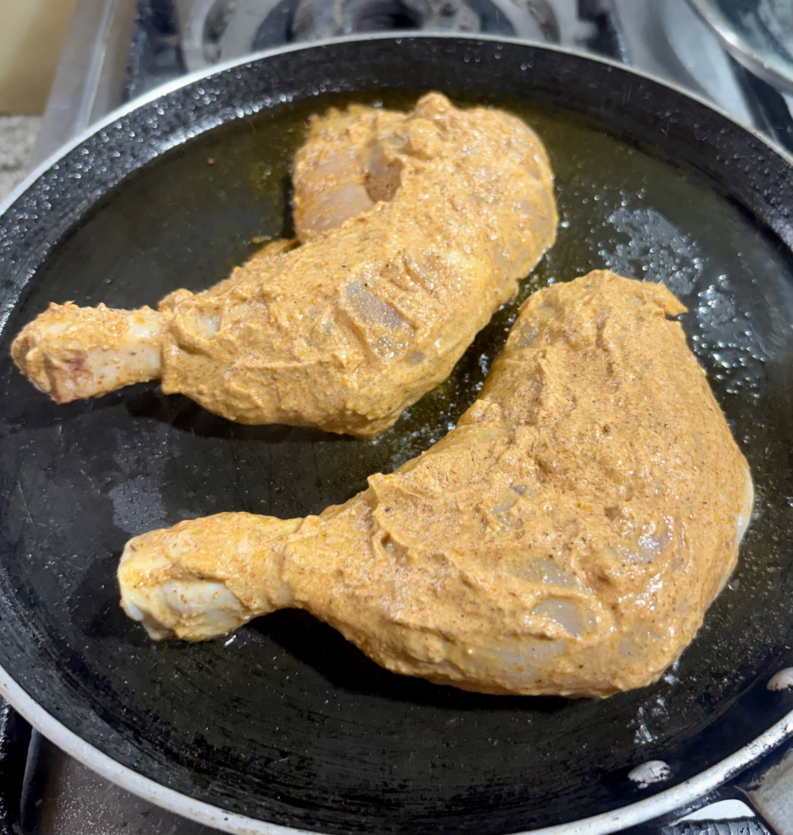 Step 2.1: Shake off any excess marinade from the chicken and place the pieces onto the hot tawa