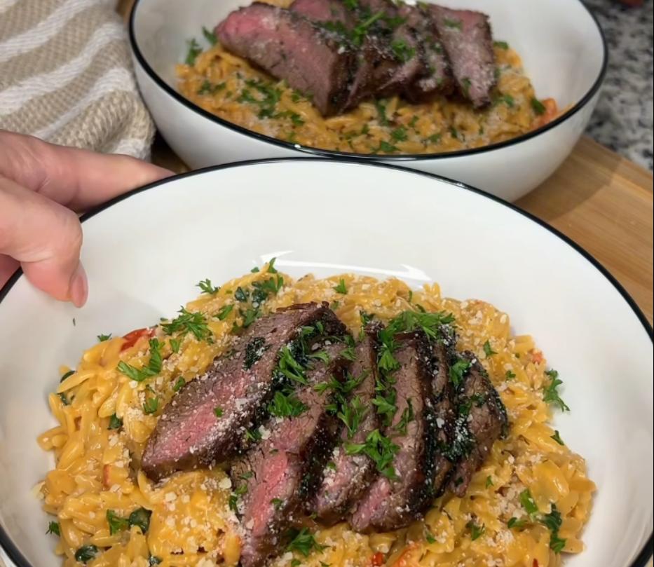 Step 3.1: Slice steak and serve over orzo, topping with grated romano and more fresh parsley