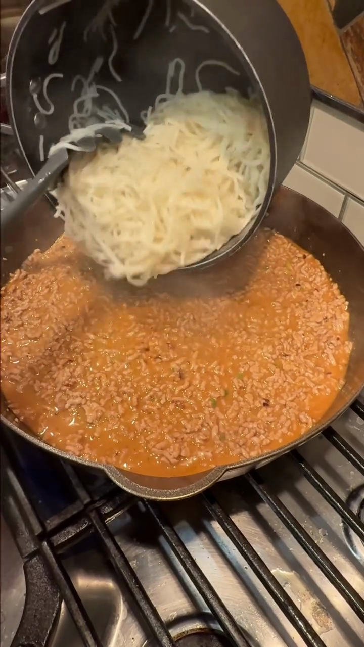 Step 5.1: Dump the cooked noodles and the remaining green onion greens into the skillet