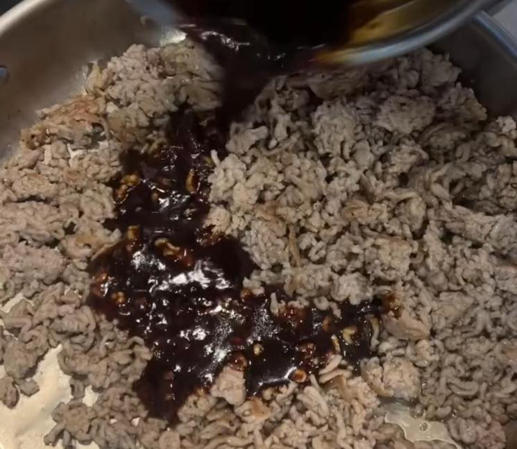 Step 2.1: Pour in the sauce and cook until it reduces and coats the pork