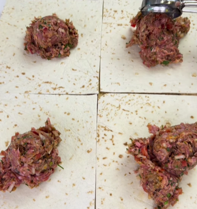 Step 2.1: Spread a thin layer of the beef mixture evenly over one tortilla square