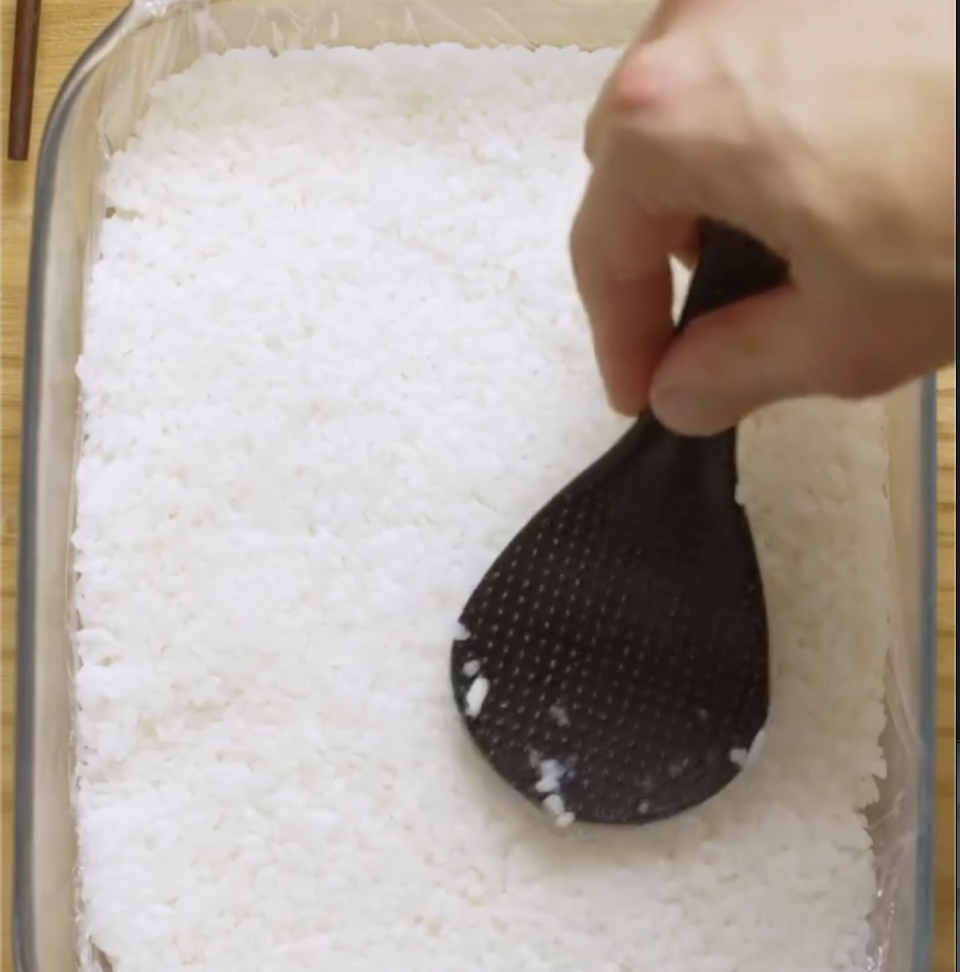 Step 1.1: Gently fluff the rice, season lightly with salt, and spread it evenly into a lined baking dish or tray