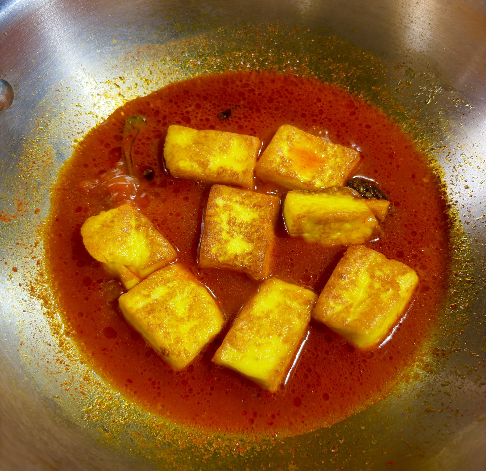 Step 5.1: Slide the fried paneer cubes into the boiling spiced water and reduce the heat to low