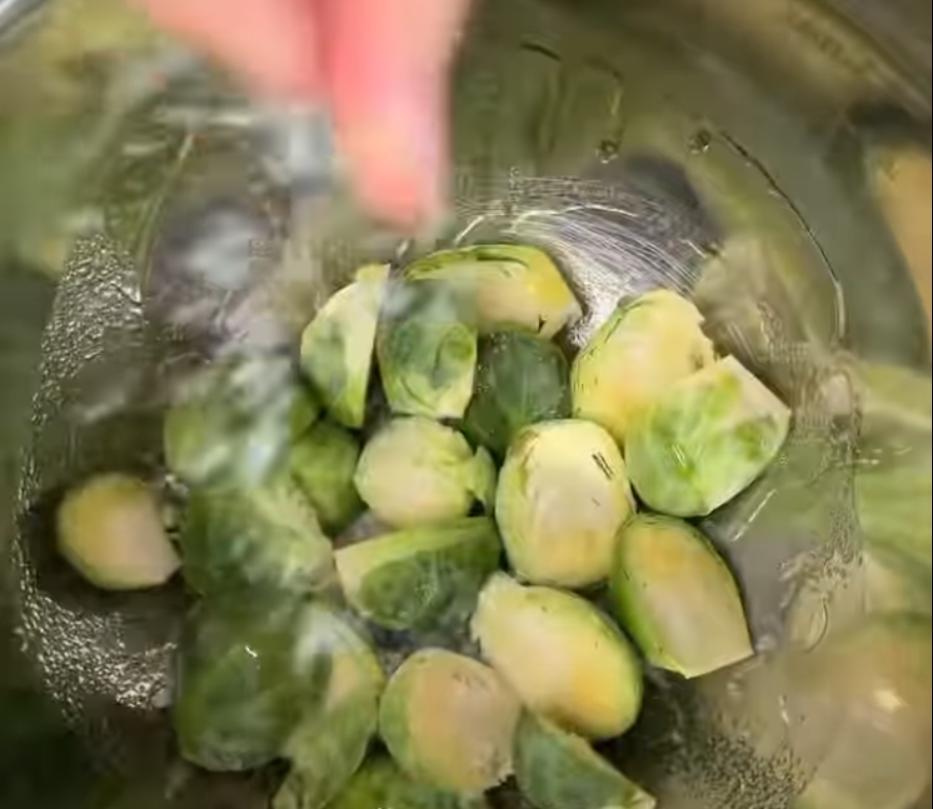 Step 2.1: Toss Brussels sprouts in a bowl with olive oil, garlic powder, salt, and pepper