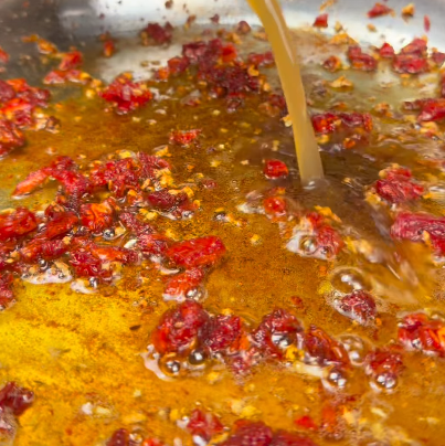 Step 1.1: Pour in the chicken broth and scrape up the brown bits from the bottom of the pan