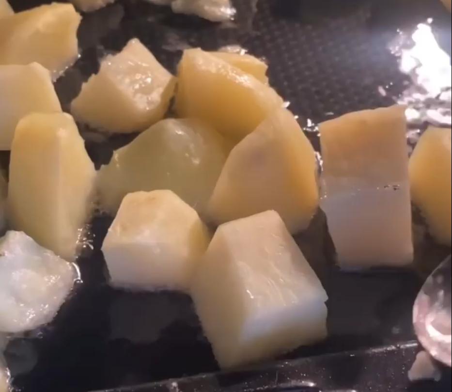 Step 1.1: Carefully drop the boiled potatoes into the tray of hot oil