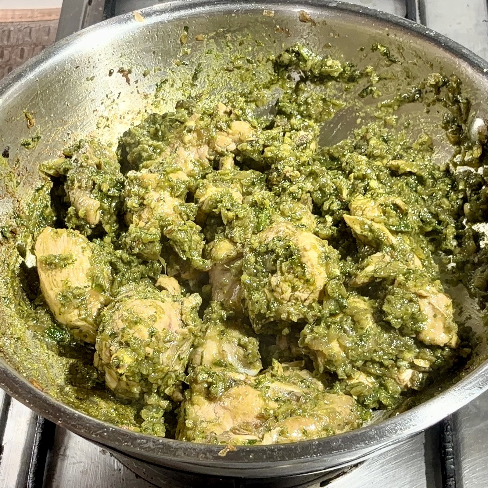 Step 4.2: Return the chicken to the kadhai and toss well to coat the pieces in the green thecha masala