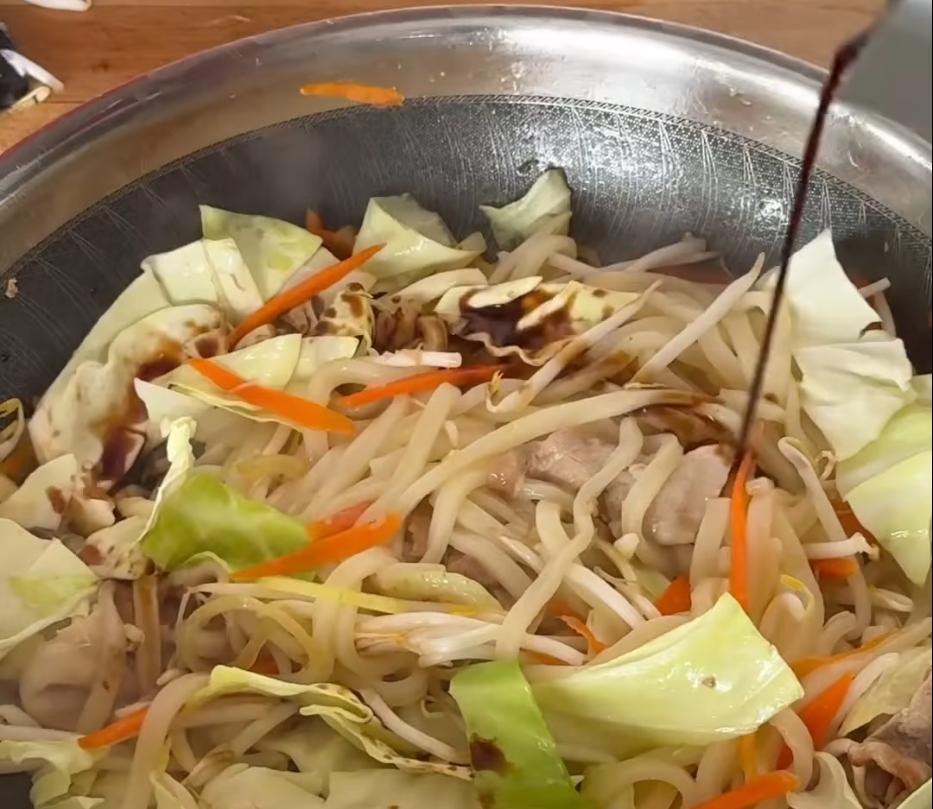 Step 1.1: Add sugar, bean sprouts and cabbage, then pour in the sauce, black pepper and spring onions