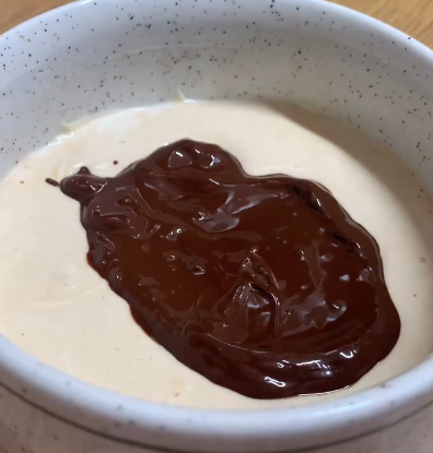 Step 1.1: Pour the melted chocolate over the yogurt mixture, spreading it evenly on top