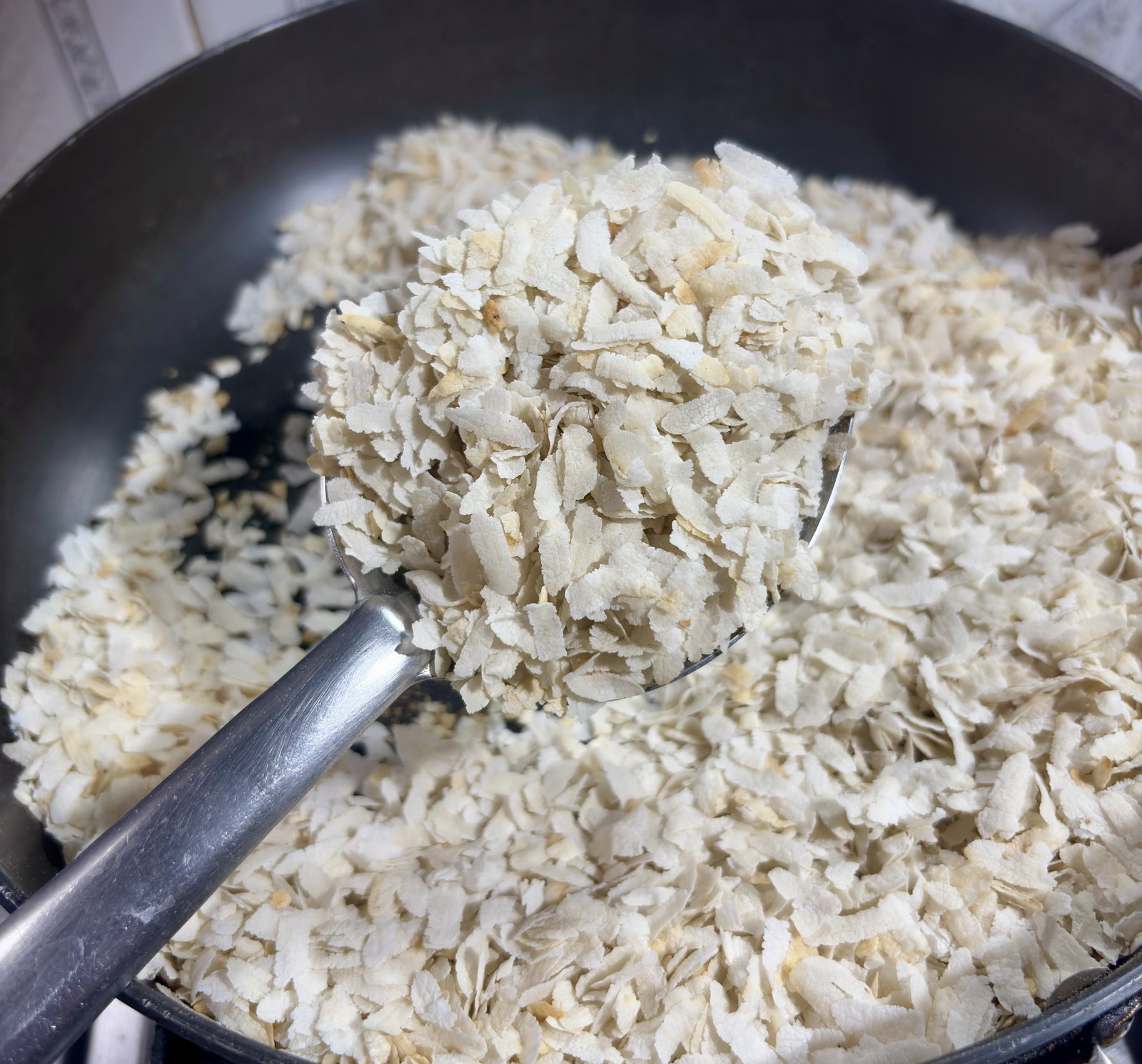 Step 1.2: Once the poha becomes crisp and slightly curls up at the edges, transfer it to a large mixing bowl and set aside