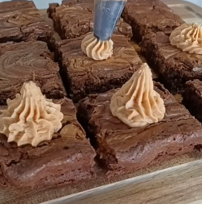 Step 2.1: Add frosting to the top of brownies with half of a Lotus Biscoff cookie