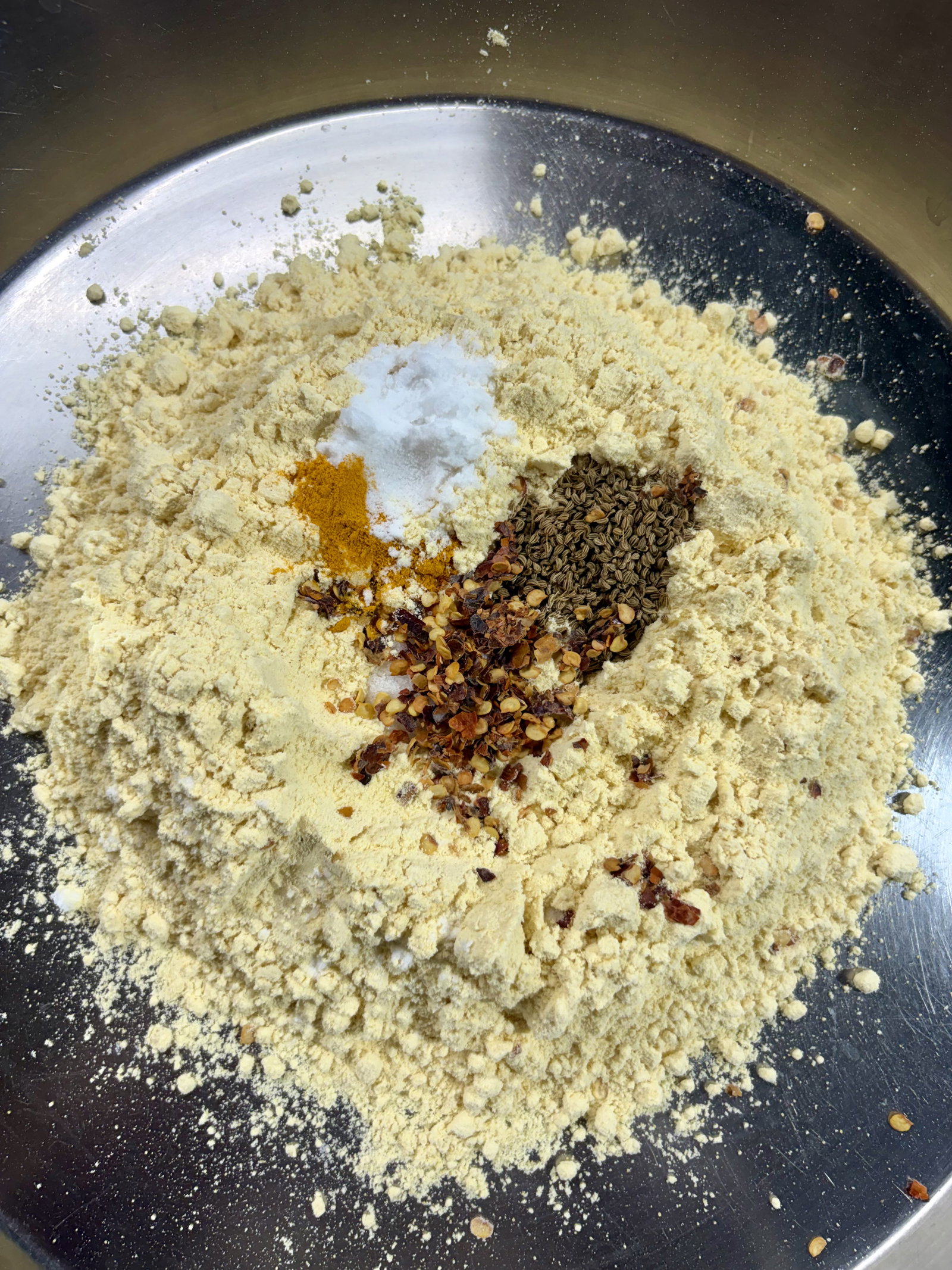 Step 2.1: In a large bowl, mix the besan, salt, ajwain, turmeric, chilli flakes, and baking soda