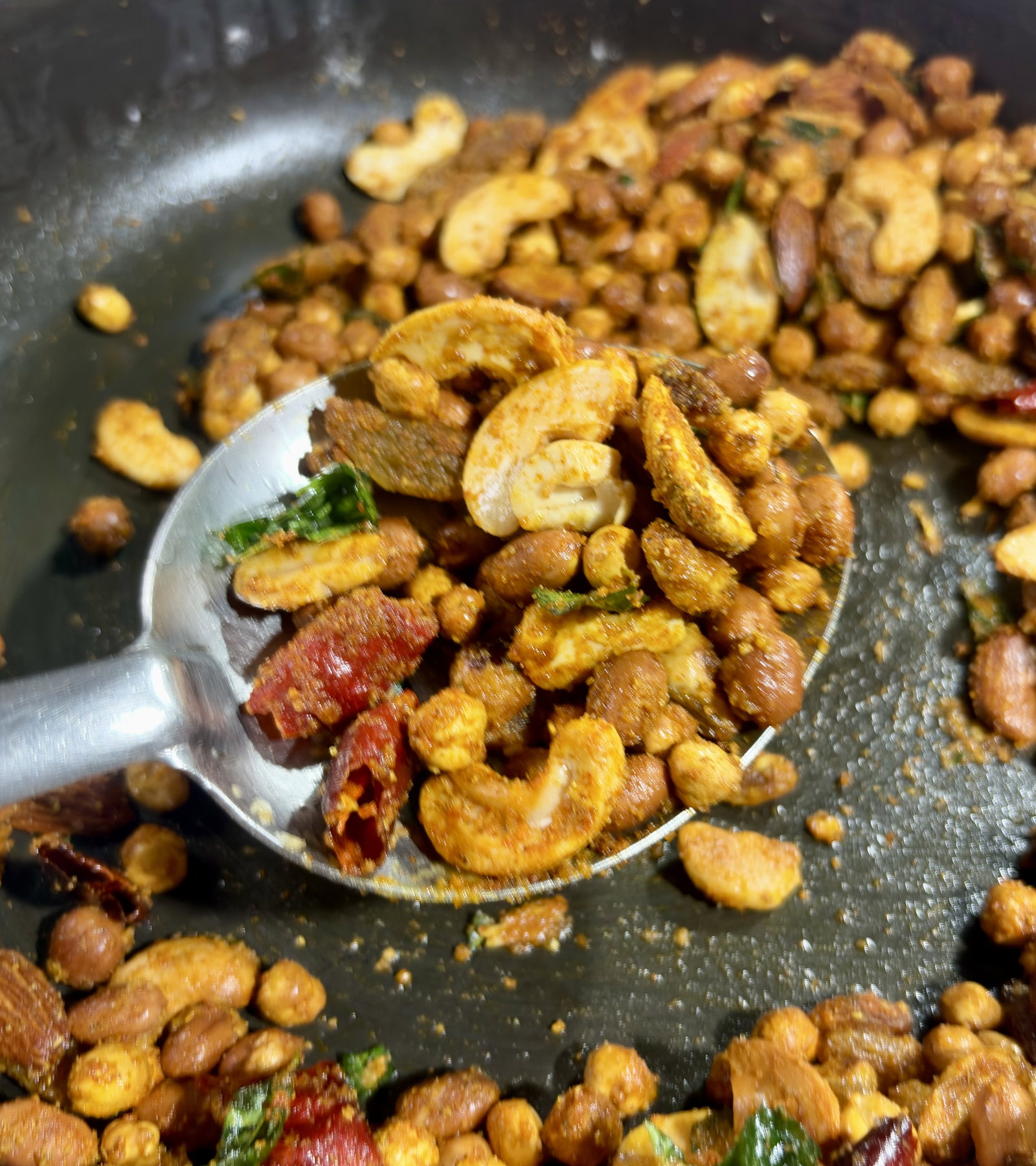 Step 3.1: Mix quickly so the spices blend evenly into the warm oil and coat the nut mixture