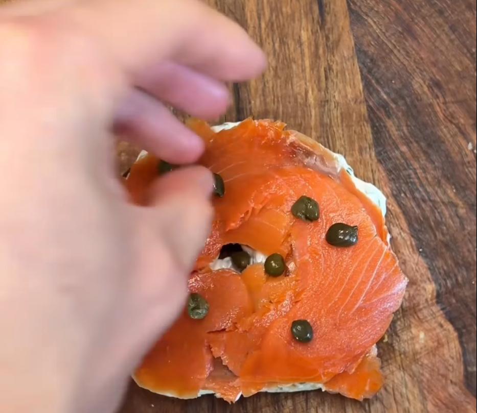 Step 1.1: Assemble bagel by spreading cream cheese mixture on both sides, topping with salmon, red onion, capers, fresh dill, and scrambled eggs