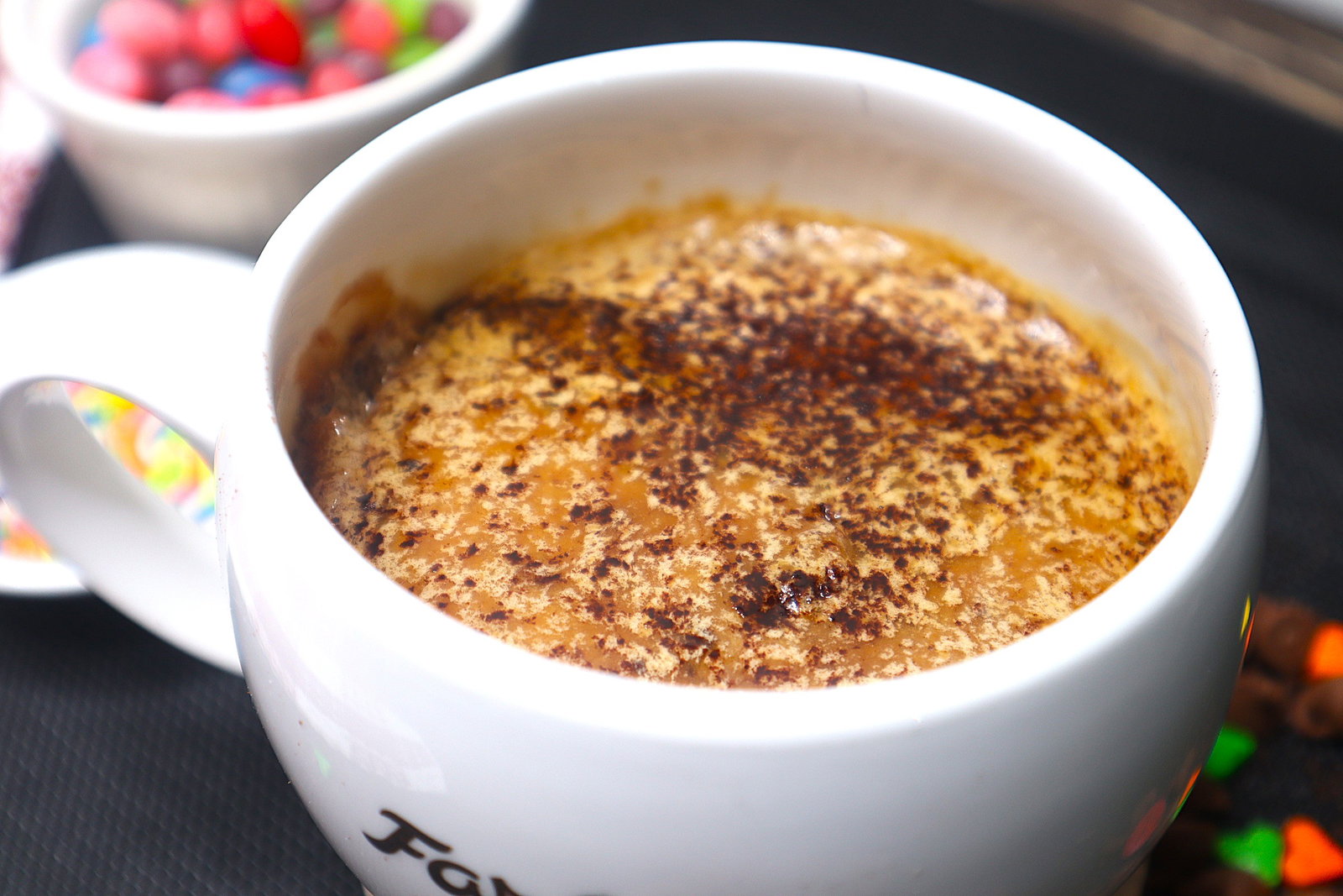 Step 1.1: Spread the frosting over the cooled mug cake and finish with a light dusting of cocoa powder